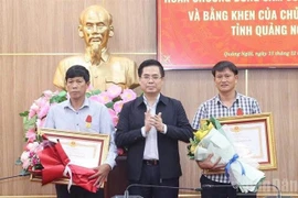 Le président du Comité populaire de la province de Quang Ngai, Nguyên Hoàng Giang, remet la Médaille du Courage du Président de la République à deux citoyens de Ly Son. Photo : VNA
