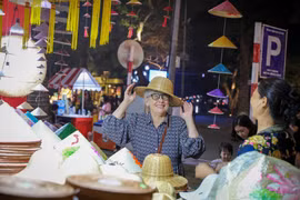 Un touriste étranger apprécie les produits traditionnels vietnamiens lors de sa découverte d'Hanoï (Photo : VNA)