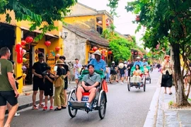 Des touristes dans la vieille ville de Hoi An, au centre du Vietnam. Photo publiée avec l'aimable autorisation du journal Phap luat (Loi).