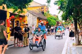 Des touristes dans la vieille ville de Hoi An, au centre du Vietnam. Photo publiée avec l'aimable autorisation du journal Phap luat (Loi).