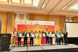 Phạm Thị Bích Hạnh (septième à partir de la droite, robe rose) reçoit le ASEAN Strong Brands Award avec d'autres lauréats. Photos gracieuseté du restaurant Quán Ăn Ngon.