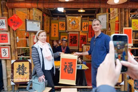Des visiteurs internationaux participent à l’activité traditionnelle de demande de calligraphie en début d’année. (Photo : VNA)