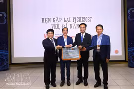 Le comité d'organisation remet le drapeau hôte de la conférence de l'année prochaine à l'Université Vietnam-R. de Corée des technologies de l'information et de la communication, rattachée à l'Université de Da Nang. (Photo : VNA)