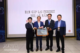 Le comité d'organisation remet le drapeau hôte de la conférence de l'année prochaine à l'Université Vietnam-R. de Corée des technologies de l'information et de la communication, rattachée à l'Université de Da Nang. (Photo : VNA)