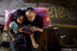 Deux enfants jouent avec un gadget à Jakarta. (Photo : ANTARA)