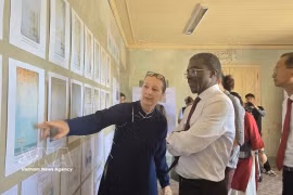 Mme Andrea Teufel, représentante principale de la Société allemande pour la préservation du patrimoine culturel au Vietnam, présente la restauration des peintures murales à M. Lazare Eloundou, directeur du Centre du patrimoine mondial de l'UNESCO. (Photo : VNA)