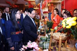 Le Premier ministre Pham Minh Chinh et son épouse visitent un stand du Têt de la communauté vietnamienne lors de l'événement (Photo : VNA)