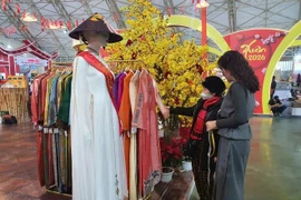 Les stands présentant l'ao dai de Hue (robe traditionnelle vietnamienne) comme un produit culturel distinctif ont suscité un vif intérêt auprès du public. Photo : VNA