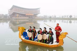 Des chanteurs et chanteuses de chant alterné (Quan ho) interprètent des chants traditionnels et échangent avec le public à bord d’une embarcation. Photo : VNA