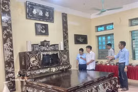 L’artisan Vũ Văn Vịnh, de la commune de Chuyên Mỹ, présente aux visiteurs un ensemble de mobilier incrusté de nacre et laqué – comprenant un lit-platforme traditionnel, une armoire à thé et des panneaux parallèles d’une valeur de plus de 3 milliards de dôngs. Photo : VNA