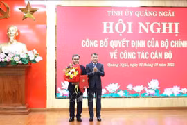 Le Minh Hung, membre du Bureau politique, secrétaire du Comité central du Parti et président de sa Commission d'organisation (droite) félicite Ho Van Nien. Photo ; VNA