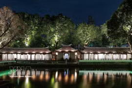 Effets lumineux projetés sur la surface des stèles en pierre et les motifs anciens, mettant en valeur les détails du patrimoine. Photo : VNA