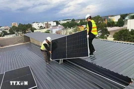 Installation de systèmes d'énergie solaire sur les toits. (Photo : VNA)
