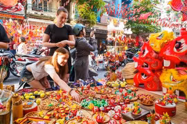 Les touristes étrangers aiment en savoir davantage sur les jouets traditionnels vietnamiens de la Fête de la mi-automne.. Photo : VNA