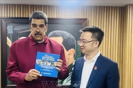 Le président vénézuélien Nicolas Maduro reçoit l'édition espagnole de « L'affection du monde pour le président Ho Chi Minh » des mains de Nguyen Tuong Lam, secrétaire du Comité central de l'Union de la jeunesse communiste Ho Chi Minh. (Photo : Ambassade du Vietnam au Venezuela)