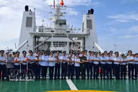 Des représentants des Garde-côtes vietnamiens et de l’Agence malaisienne de contrôle maritime (MMEA) de Pahang prennent une photo souvenir selon la tradition de l’ASEAN à bord du CSB 8005. Photo : VNA 