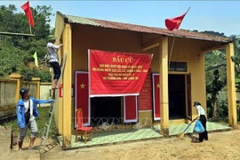 Des habitants de l’ethnie Bru-Vân Kiều du village de Nuoc Dang, commune de Truong Son (province de Quang Tri), décorent le bureau de vote afin de se préparer au scrutin anticipé prévu le 8 mars. Photo : VNA