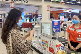 Un client effectue un paiement par QR code dans un supermarché. Photo enternews.vn