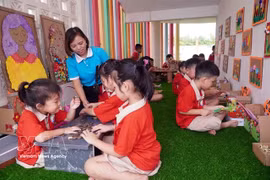 Une enseignante et des enfants du jardin d'enfants Tran Cao de la commune de Quang Hưng, province de Hung Yên, participent à des activités d'apprentissage expérientiel. Photo : VNA