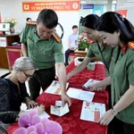 Des agents du Département de l’immigration aident une ressortissante étrangère à Hanoi à remplir les formulaires pour les comptes d’identification électronique de niveau 2 avec VneID, le 1er juillet. Photo : VNA
