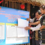Des gens consultent la liste des électeurs et des candidats affichée dans les maisons communales des villages de la province de Quang Ngai. Photo : VNA