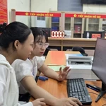 Trân Thi Kim Nhung, une agente publique du quartier de Phu Liên, à Hai Phong, explique comment déposer un dossier d’enregistrement de mariage via le Portail national de la fonction publique. Photo : VNA