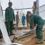 Des soldats aident des habitants de la commune de Pa Ủ (province de Lai Châu) à stabiliser leurs conditions de vie après une tempête de grêle et de forts vents survenus vers 18 heures le 17 mars. Photo: VNA