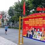 Un homme faisant de la gymnastique passe près ds banderoles et des slogans sur les élections législatives affichés dans les zones résidentielles et les espaces publics du quartier de Thông Tây Hôi, à Hô Chi Minh-Ville. Photo : Journal "Tin tuc và Dân tôc"