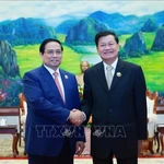 Le Premier ministre Pham Minh Chinh et le secrétaire général du Parti révolutionnaire populaire lao et président du Laos, Thongloun Sisoulith se serrent la main, à Vientiane, le 3 décembre. Photo : VNA