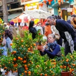 Deux touristes étrangers au marché aux fleurs de Hàng Luoc, à Hanoi, lors du Têt du Cheval 2026. Photo: VNA
