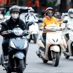 Des gens se déplacent pour se rendre au travail par une journée froide à Hanoi. Photo : VNA