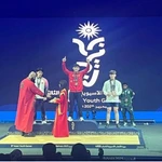 L’haltérophile Nguyên Thành Duy (au centre) sur la plus haute marche du podium, aux Jeux asiatiques de la jeunesse 2025, à Bahreïn, le 27 octobre. Photo : D.Q
