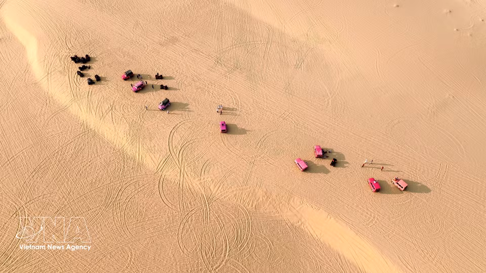 Des véhicules touristiques ponctuent de couleurs vives les dunes de Mui Dinh. Photo : VNA