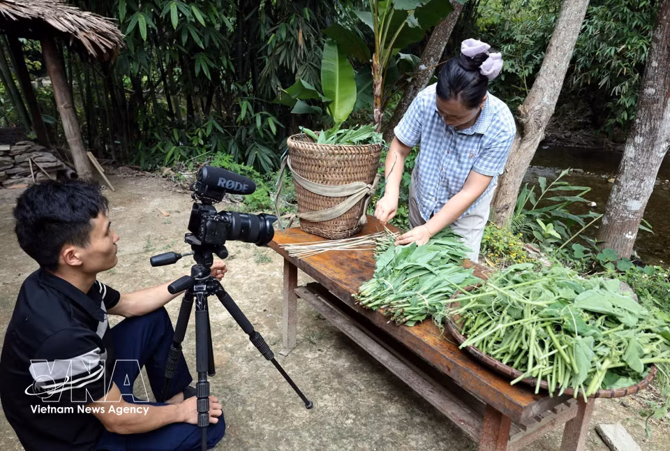 La célèbre YouTubeuse Ly Thi Ca, de l’ethnie Dao et du hameau de Khau Cau, suivie par des millions d'abonnés, enregistre une vidéo présentant des produits du terroir. Photo : VNA.