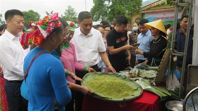 Des dirigeants de la province de Lào Cai et des habitants visitent les stands présentant les produits de côm de Hop Thanh. Photo : VNA