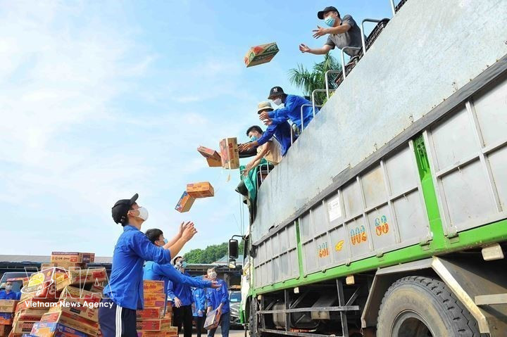 Les jeunes de Hanoï réceptionnent et transportent des produits de première nécessité vers les zones confinées et isolées, soutenant les travailleurs et les personnes vulnérables touchées par la pandémie de COVID-19 (septembre 2021). Photo: VNA