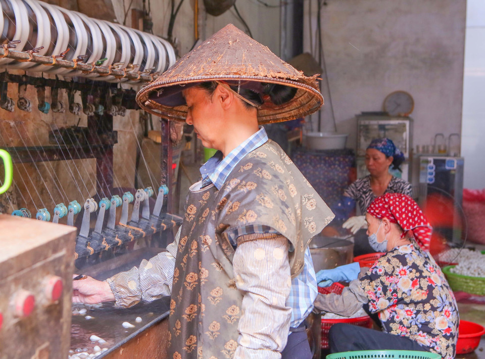 Artisans remuant les cocons, nouant et affinant les fils de soie. Photo : VNA
