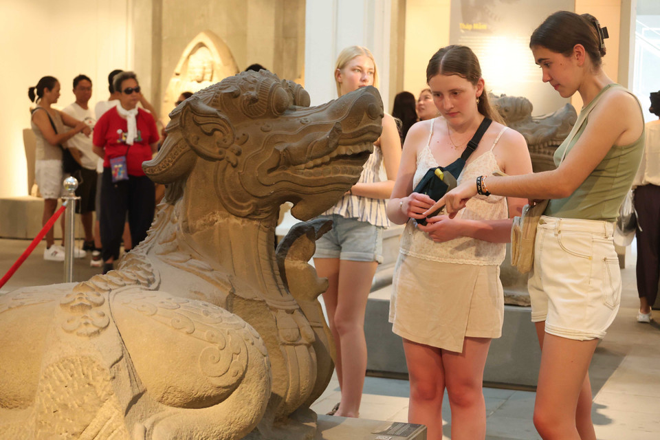 Des visiteurs étrangères s’intéressent à la sculpture du monstre marin Makara, une figure emblématique de la mythologie Cham. Photo: Kha Pham – VNA