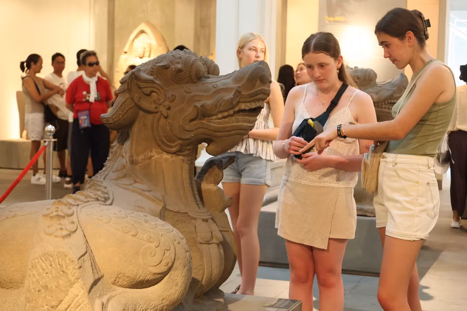 Des visiteurs étrangères s’intéressent à la sculpture du monstre marin Makara, une figure emblématique de la mythologie Cham. Photo: Kha Pham – VNA