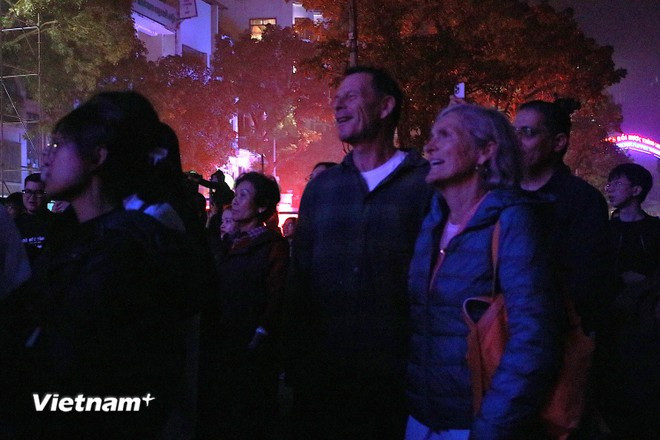 La scène du Vietnam Happy Fest 2025 capte l'attention de nombreux touristes étrangers, qui s'arrêtent pour partager l'ambiance festive. (Photo : Vietnam+)