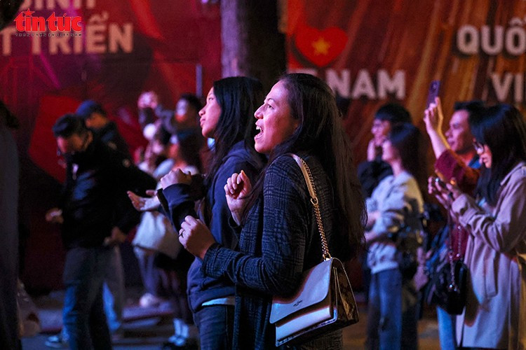 Captivés par l’événement, de nombreux touristes étrangers savourent l’atmosphère chaleureuse et les émotions partagées par le public. (Photo : Journal Tin Tuc – VNA)