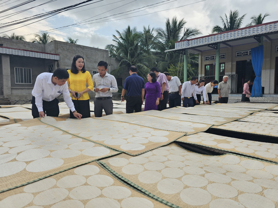 Des touristes assistent au séchage traditionnel des galettes soufflées dans le village artisanal de Son Doc. Photo : Chuong Dai - VNA