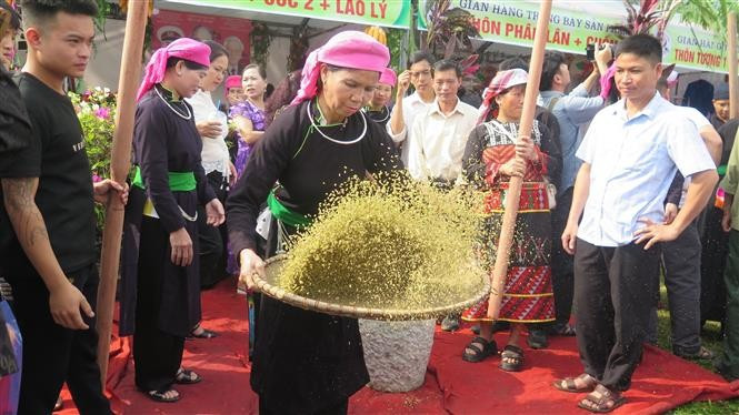 Une femme Tày de Hop Thanh tamisant le côm — une étape indispensable du processus de préparation. Photo : VNA