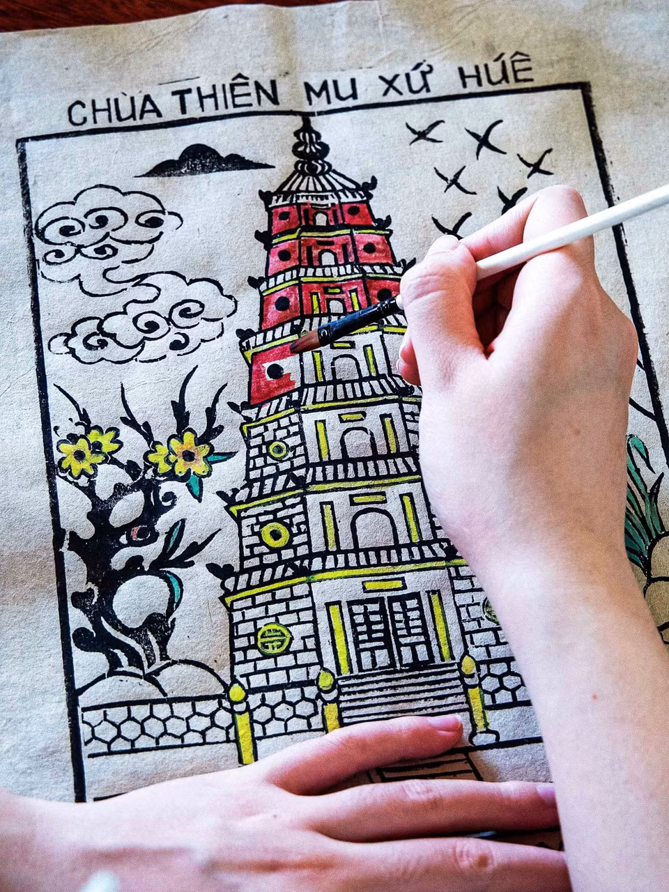 Pour répondre à l’essor du tourisme, l’artisan Pham Cong Khai a créé de nouvelles planches gravées représentant des sites emblématiques de Hue, tels que la Pagode Thiên Mu et le Pont Truong Tien, transformant ainsi cet art spirituel ancestral en souvenir culturel original destiné aux visiteurs. Photo : VNA