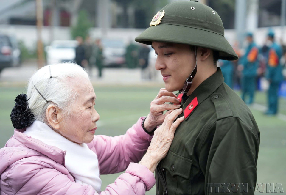 Nguyên Thi Minh Thuân, âgée de 90 ans et domicilée dans dans l'arrondissement de Dông Da, à Hanoi, encourage son petit-fils avant son départ pour sa mission de sécurité publique, en février 2025. Photo : VNA