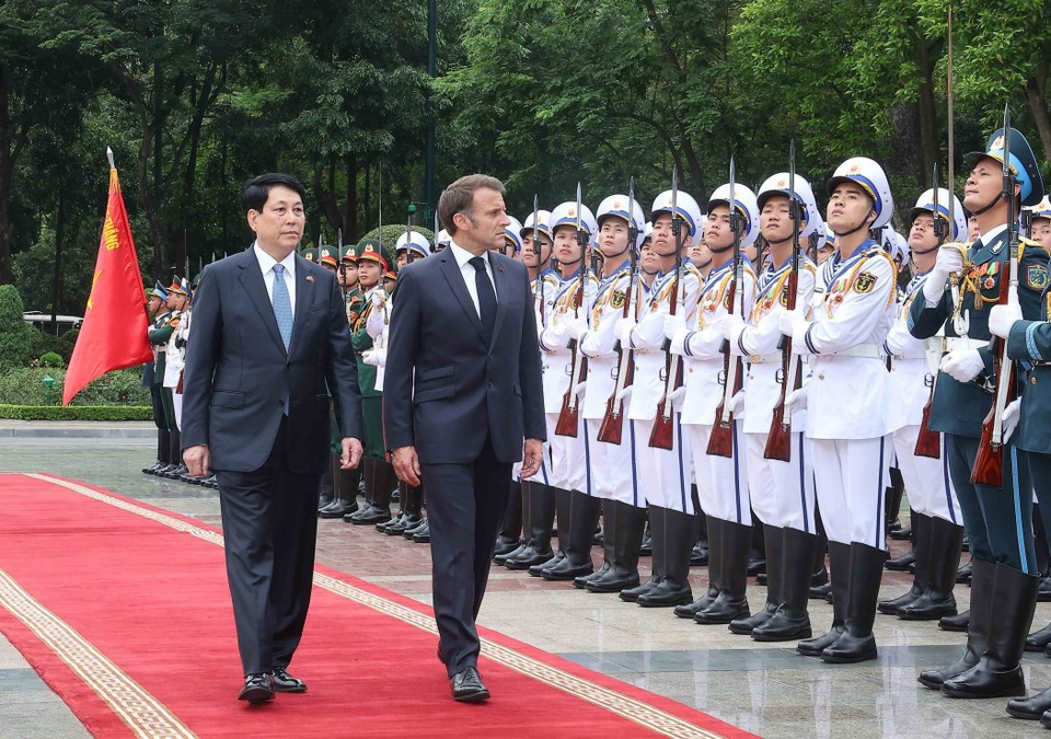 Le président Luong Cuong et le président français Emmanuel Macron passent en revue la garde d'honneur de l'Armée populaire du Vietnam. Photo : VNA