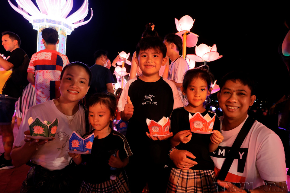 Une famille participe à un lâcher de lanternes de fleurs lors de la Semaine du Festival international des arts de Huê 2024. Photo : Minh Quyêt – VNA