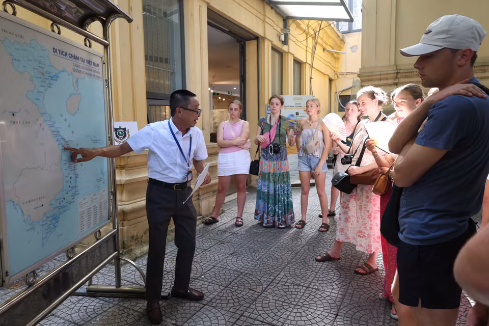 Des touristes étrangers écoutent les explications d’un guide au Musée de la sculpture Cham de Dà Nang. Photo: Kha Pham – VNA