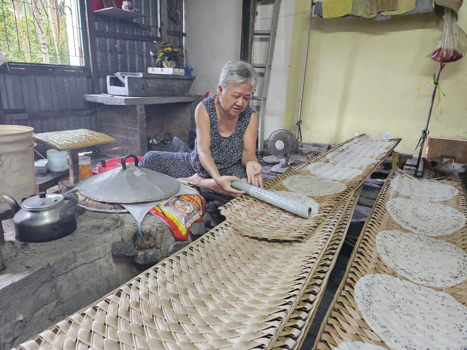 Une vieille femme du hameau de Nghia Huan, dans la commune de My Thanh (district de Giong Trom), perpétue la tradition séculaire du village artisanal de galettes de riz de My Lông, transmis de génération en génération depuis plus de cent ans. Photo : Chuong Dai - VNA