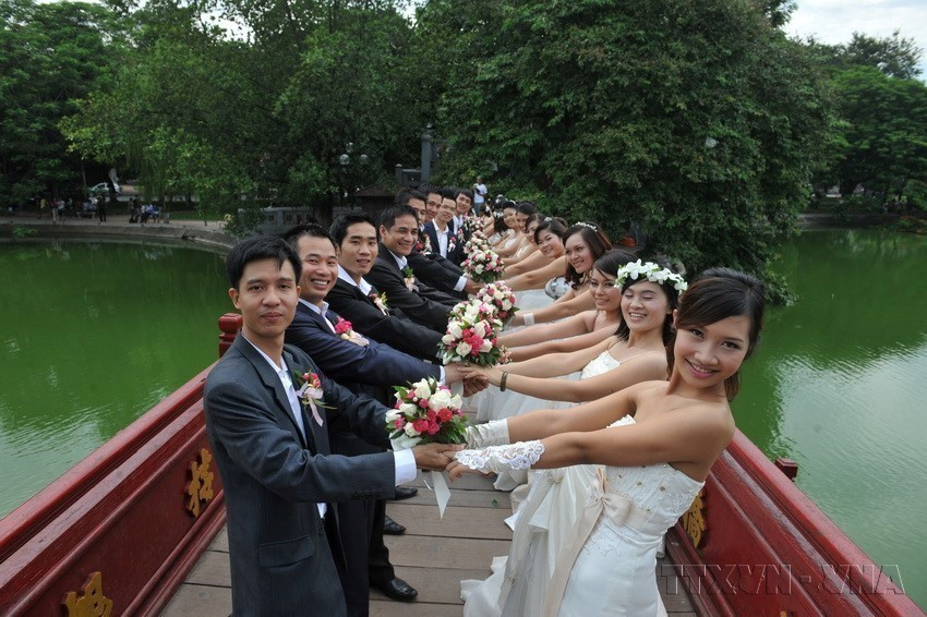 Photo d'un mariage de 50 couples venus des trois régions - Nord, Centre et Sud - au lac Hoàn Kiêm (Epée restituée), à Hanoï. Photo : VNA